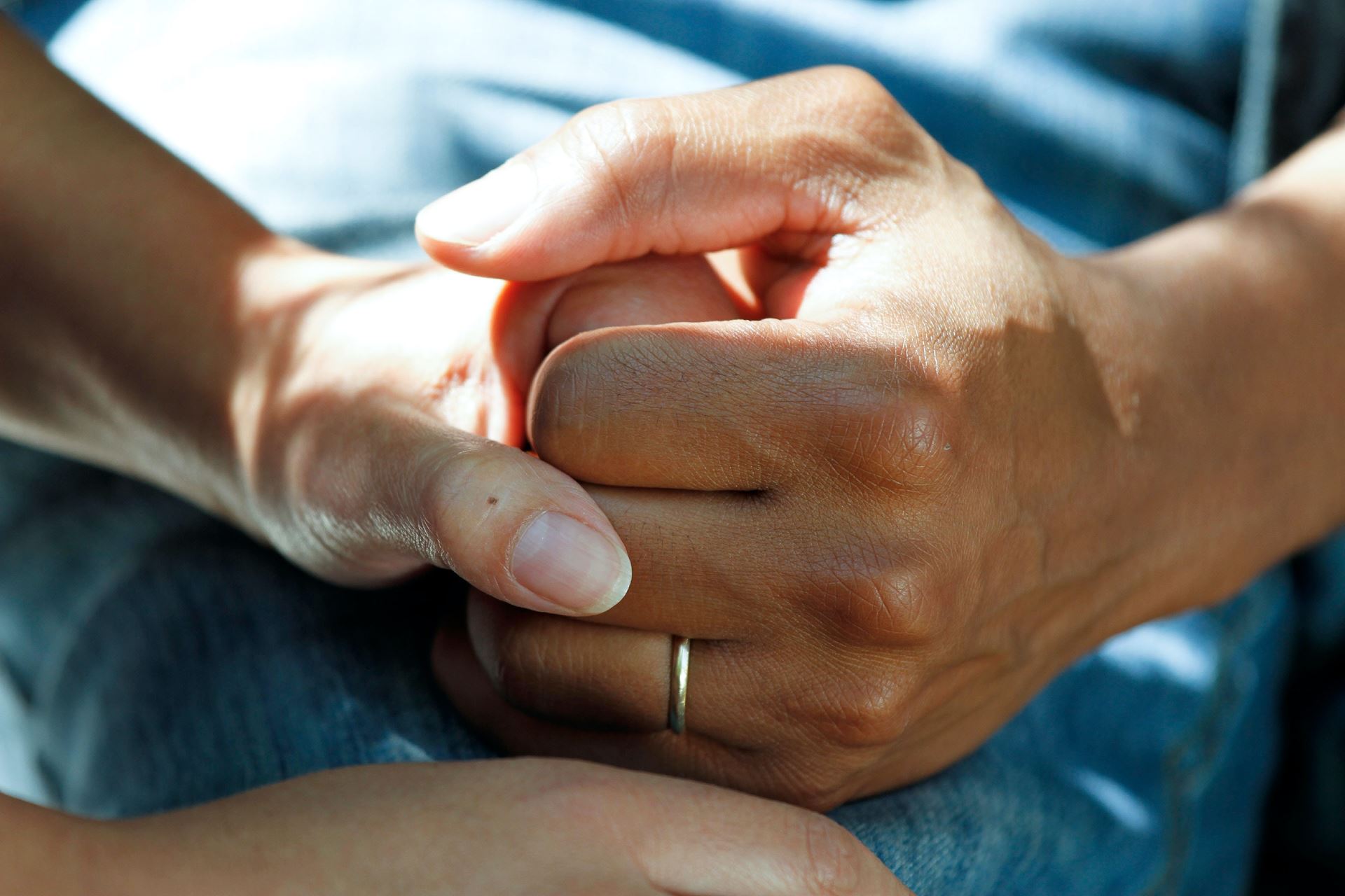 A zoomed in photo of two people holding hands