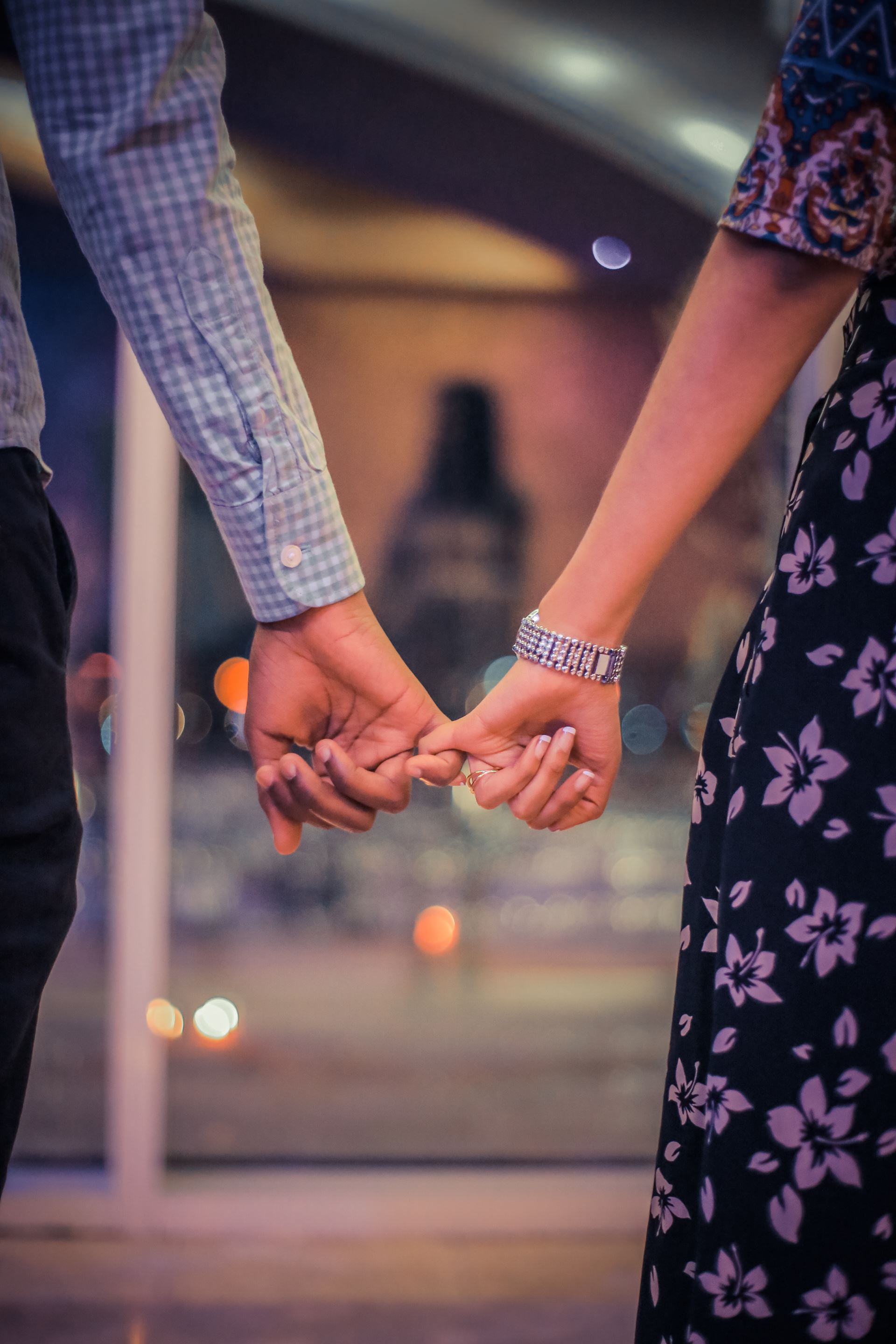 A couple linking their little fingers together