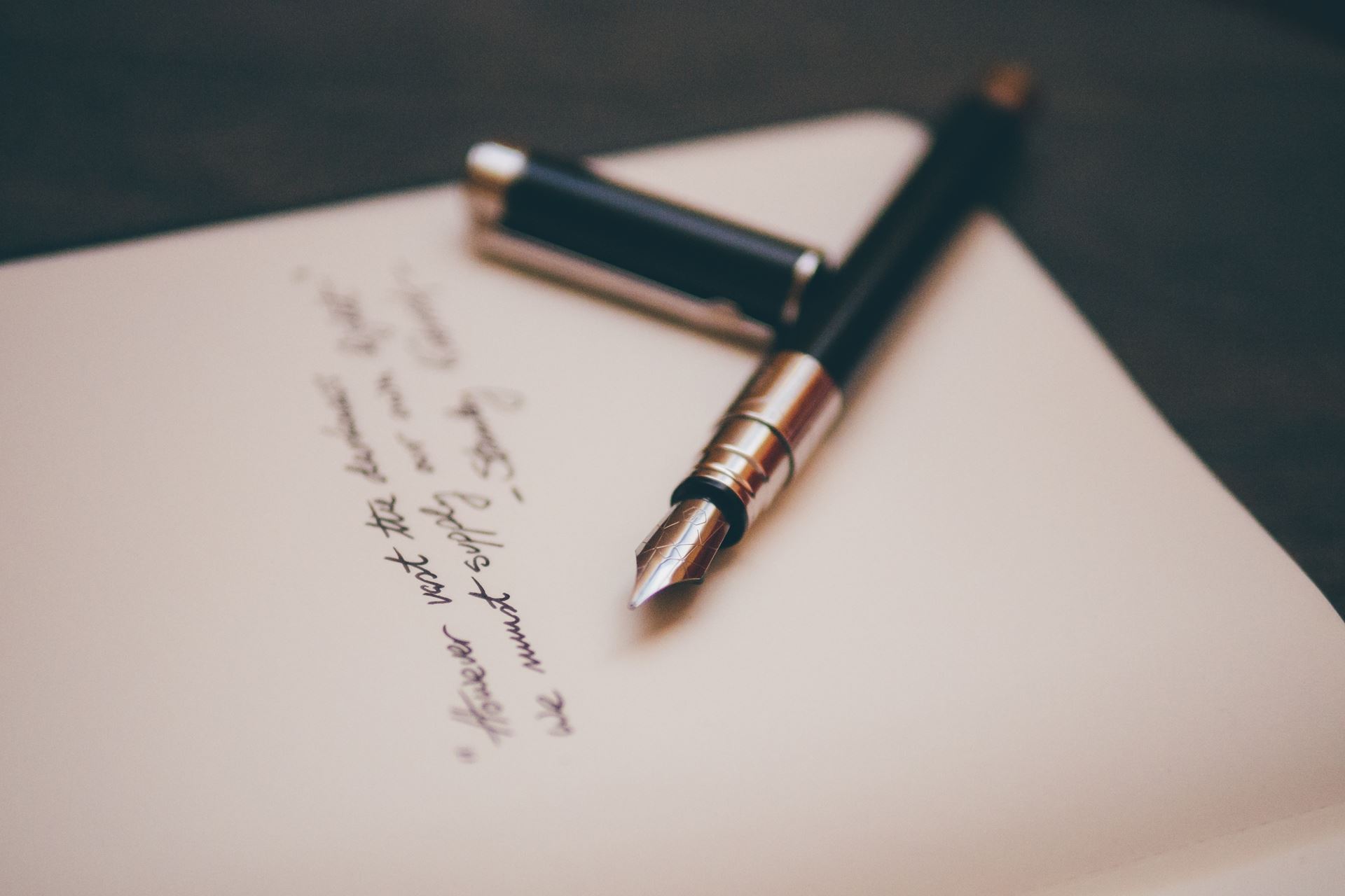 A fountain pen resting on a handwritten letter